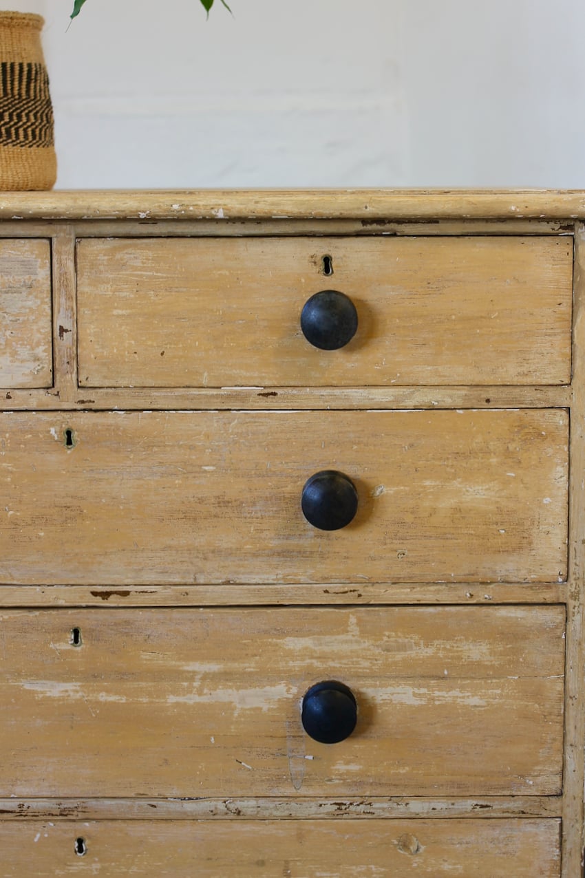beautiful antique original painted pine english chest of drawers with contrasting black knobs and original turned feet.