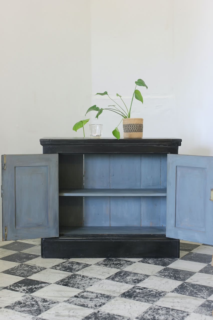 lovely old english two door pine cupboard with a painted black exterior, contrasting blue interior,  shelf inside & a deep plinth.