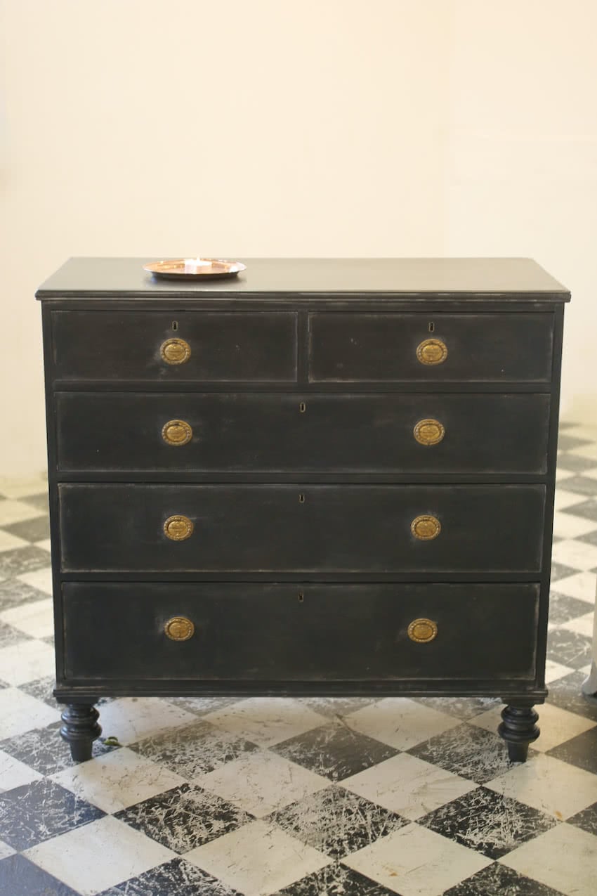 gorgeous black georgian style chest of drawers with beautiful brass original handles and pretty tall turned feet.
