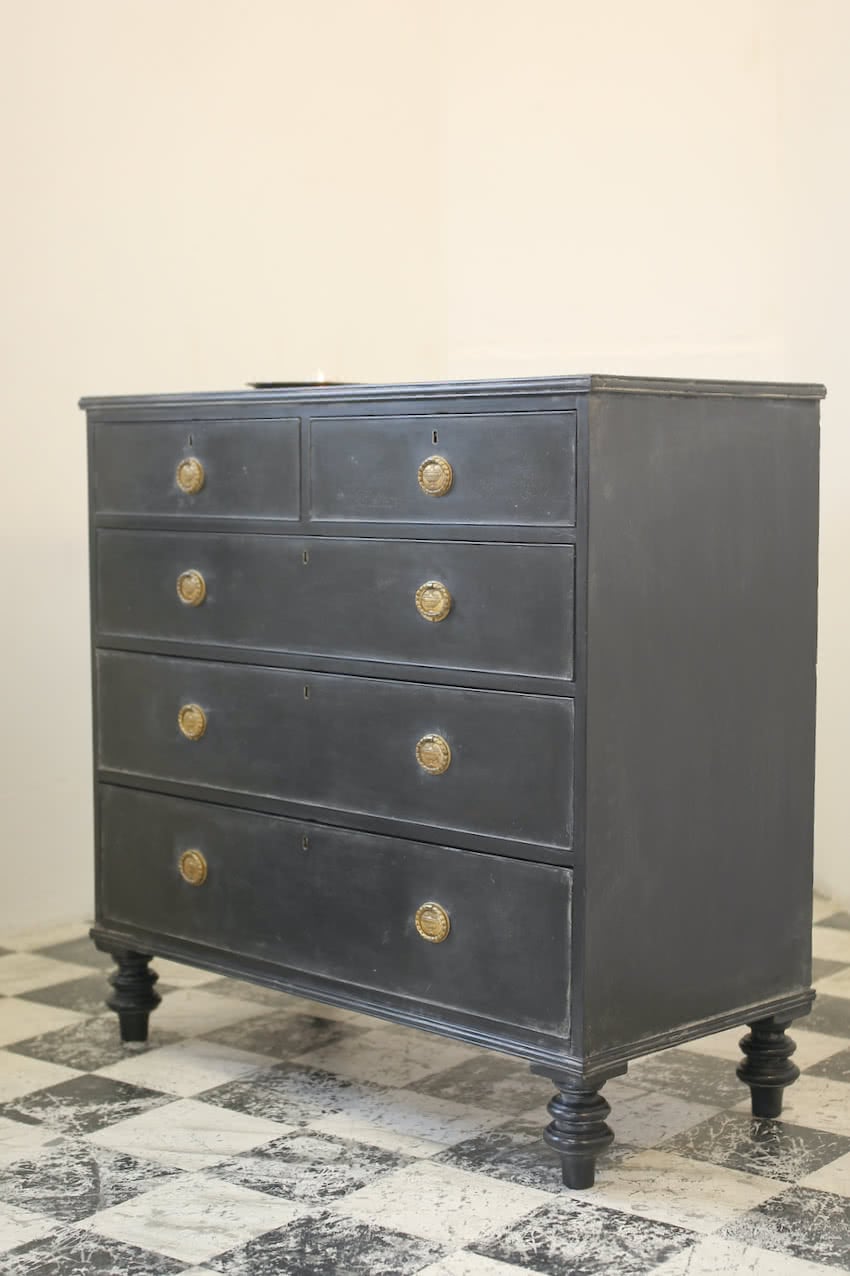 gorgeous black georgian style chest of drawers with beautiful brass original handles and pretty tall turned feet.