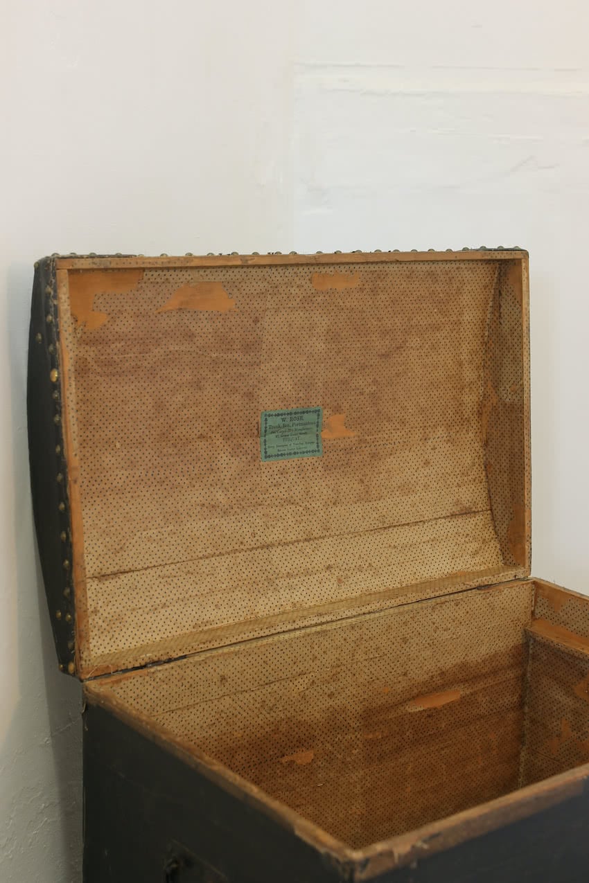linen covered & studded black trunk from dorset, vintage paper lined, ironwork handles &  wear and tear shown in photos.