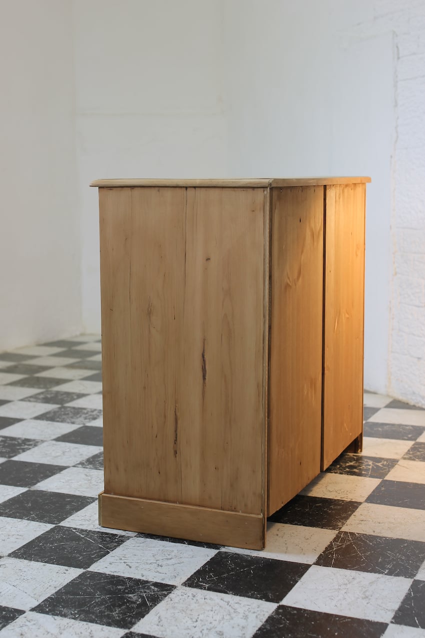 classic english deep four drawer antique pine chest completey restored standing on a plinth with new knobs.