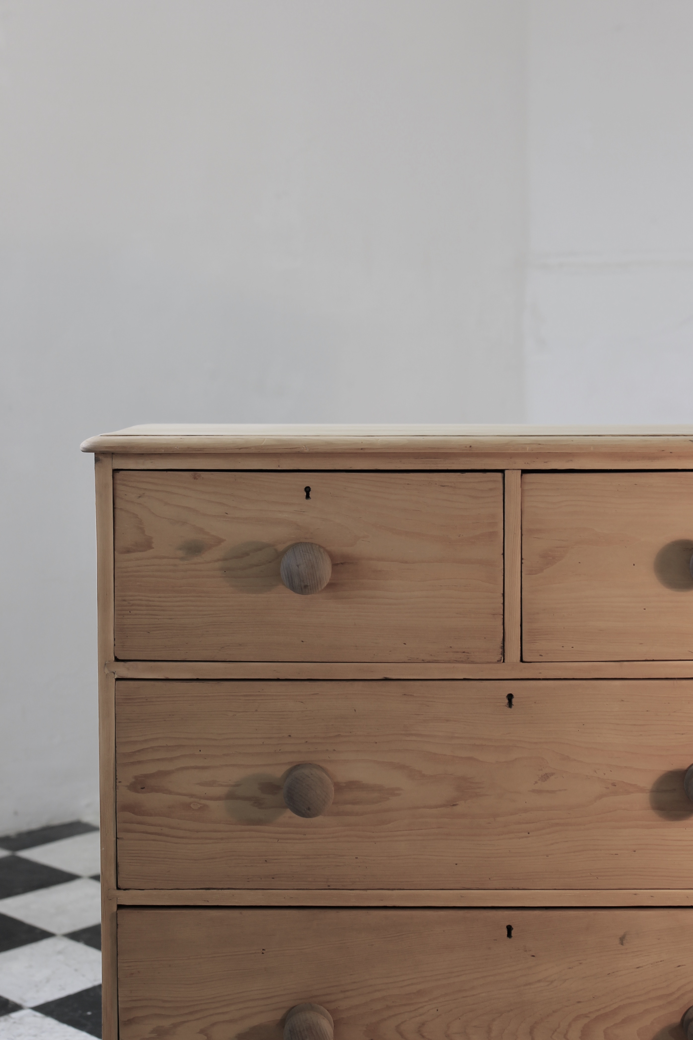 classic english deep four drawer antique pine chest completey restored standing on a plinth with new knobs.
