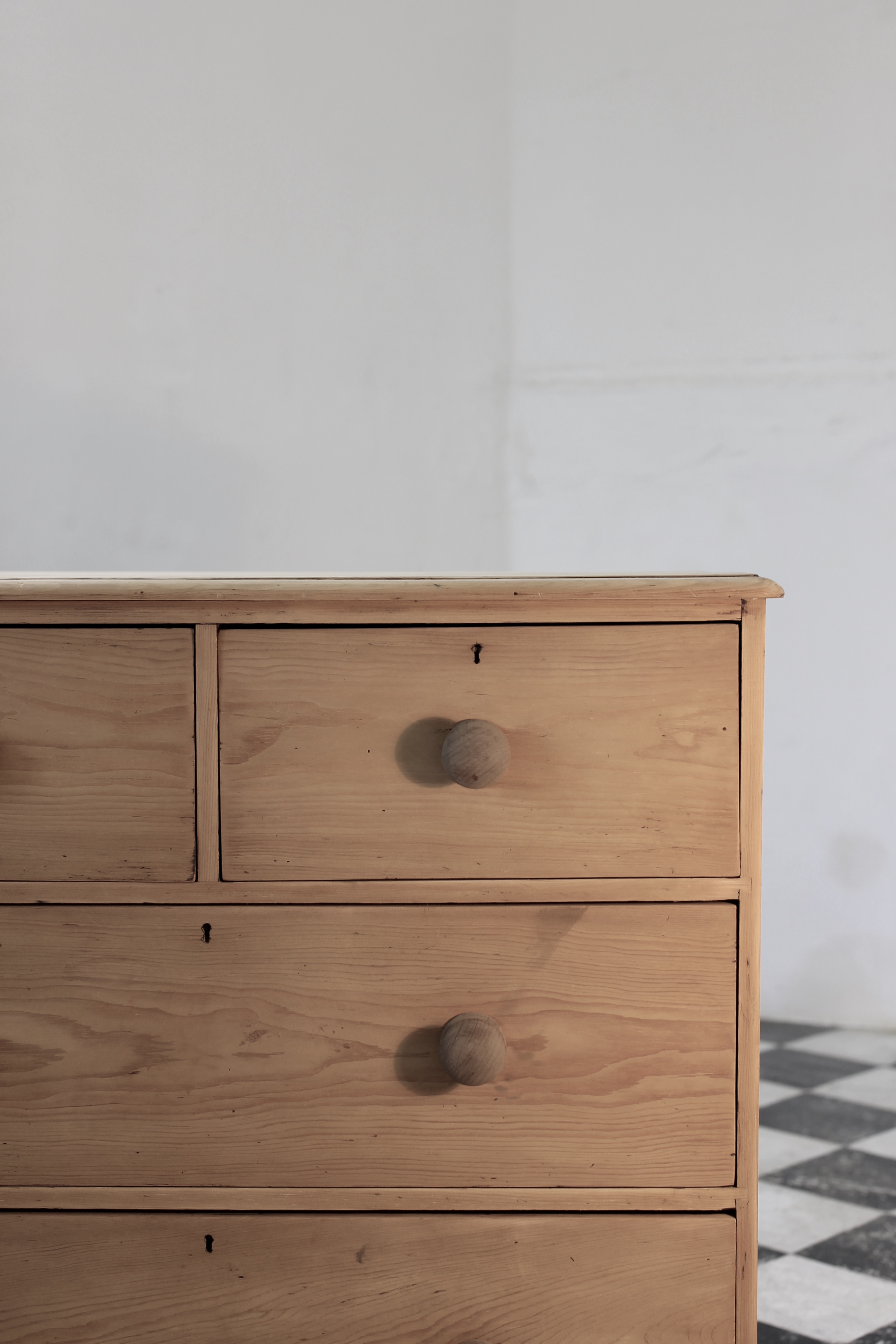 classic english deep four drawer antique pine chest completey restored standing on a plinth with new knobs.