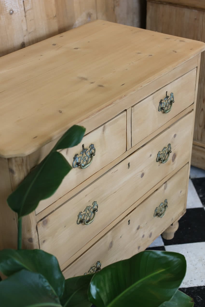 restored pine english chest of drawers, with two short drawers over two long, with brass swan neck handles, new turned feet & a dry finish.