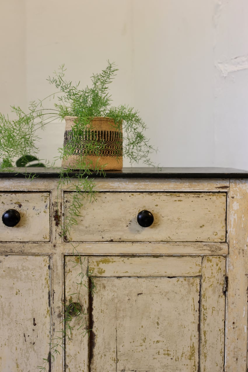 lovely english original painted pine three drawer cupboard base with part painted green interior, black wooden knobs and large brass escutcheons.