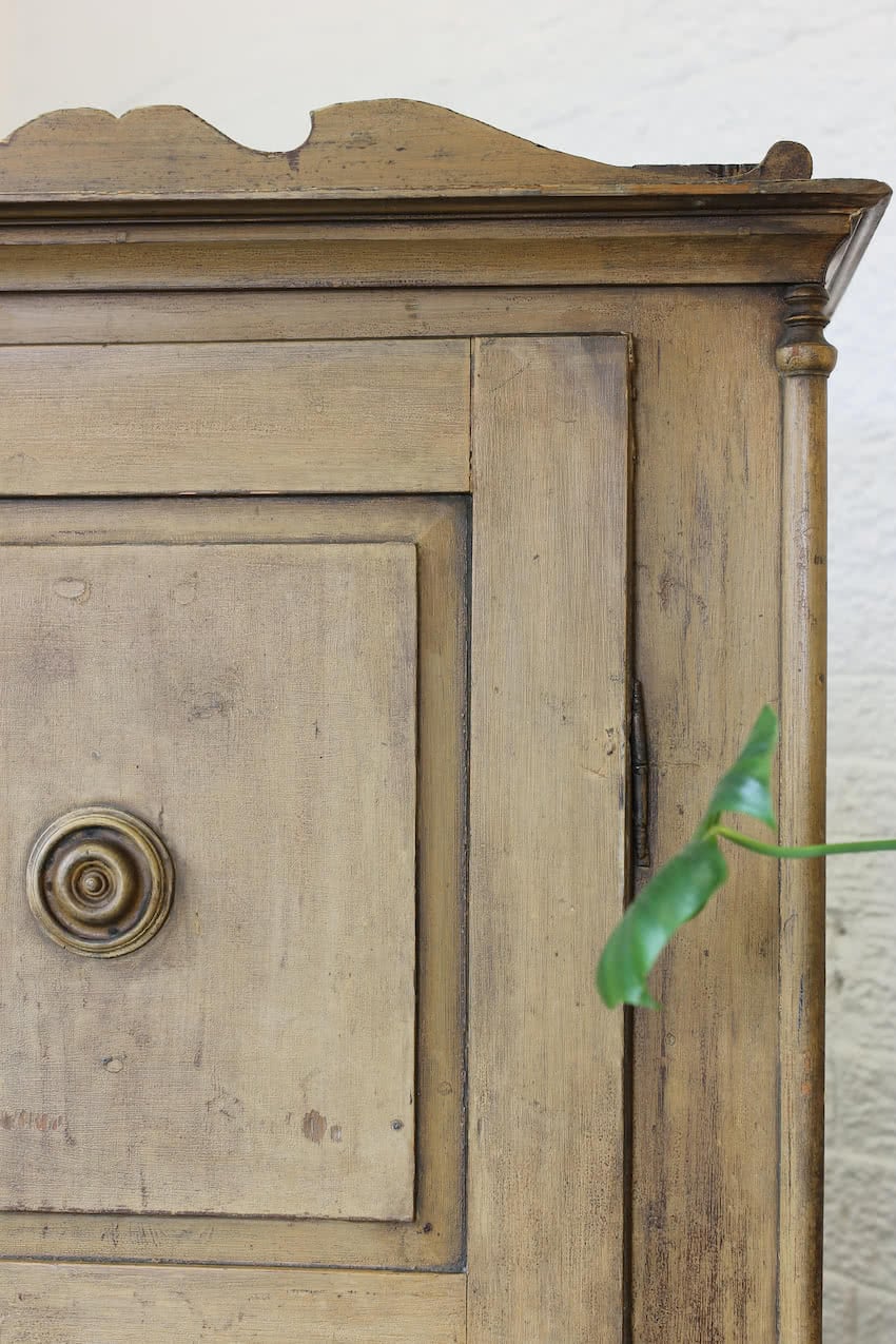 original painted yellow ochre early tall pine cupboard with slghtly crackled old paint, shelf & drawer, shaped cornice and columned feet & round brass key plate.