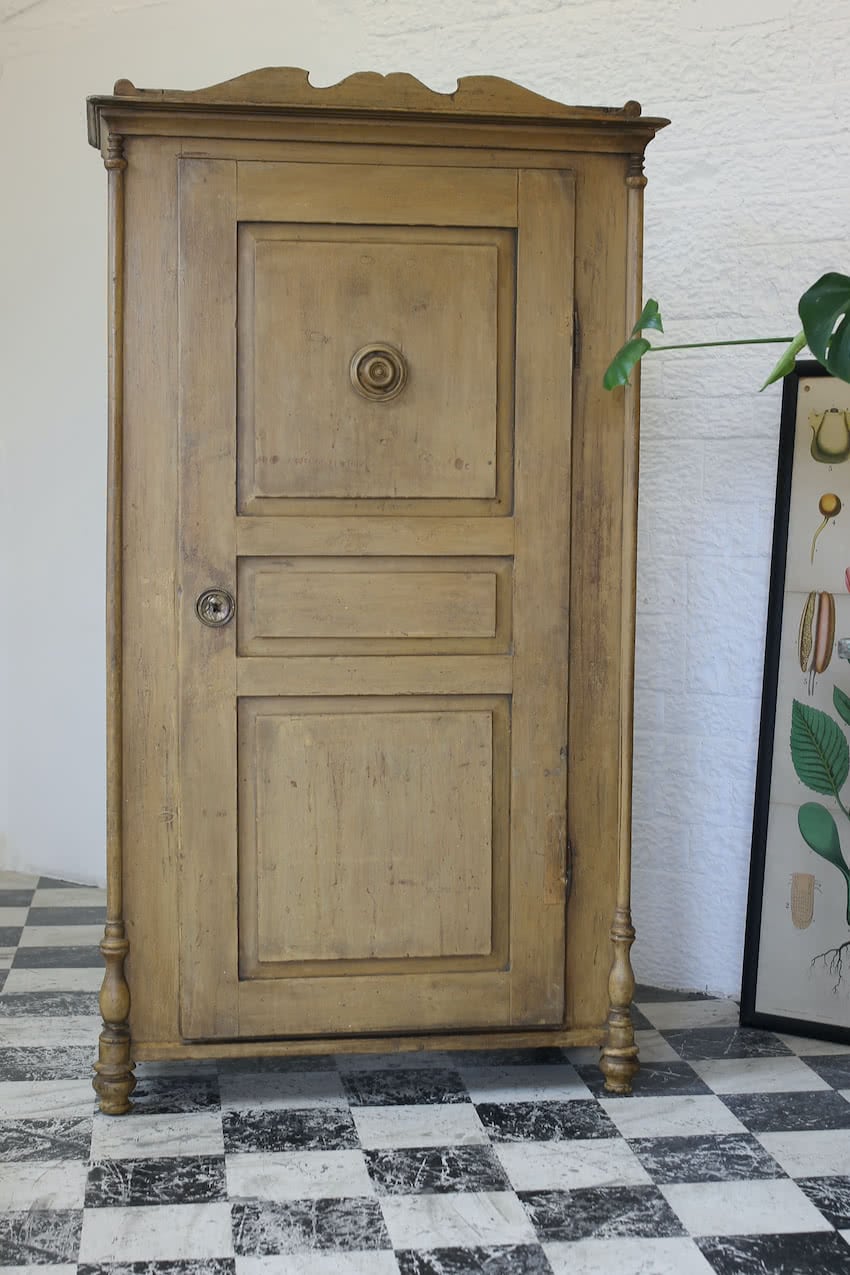 original painted yellow ochre early tall pine cupboard with slghtly crackled old paint, shelf & drawer, shaped cornice and columned feet & round brass key plate.