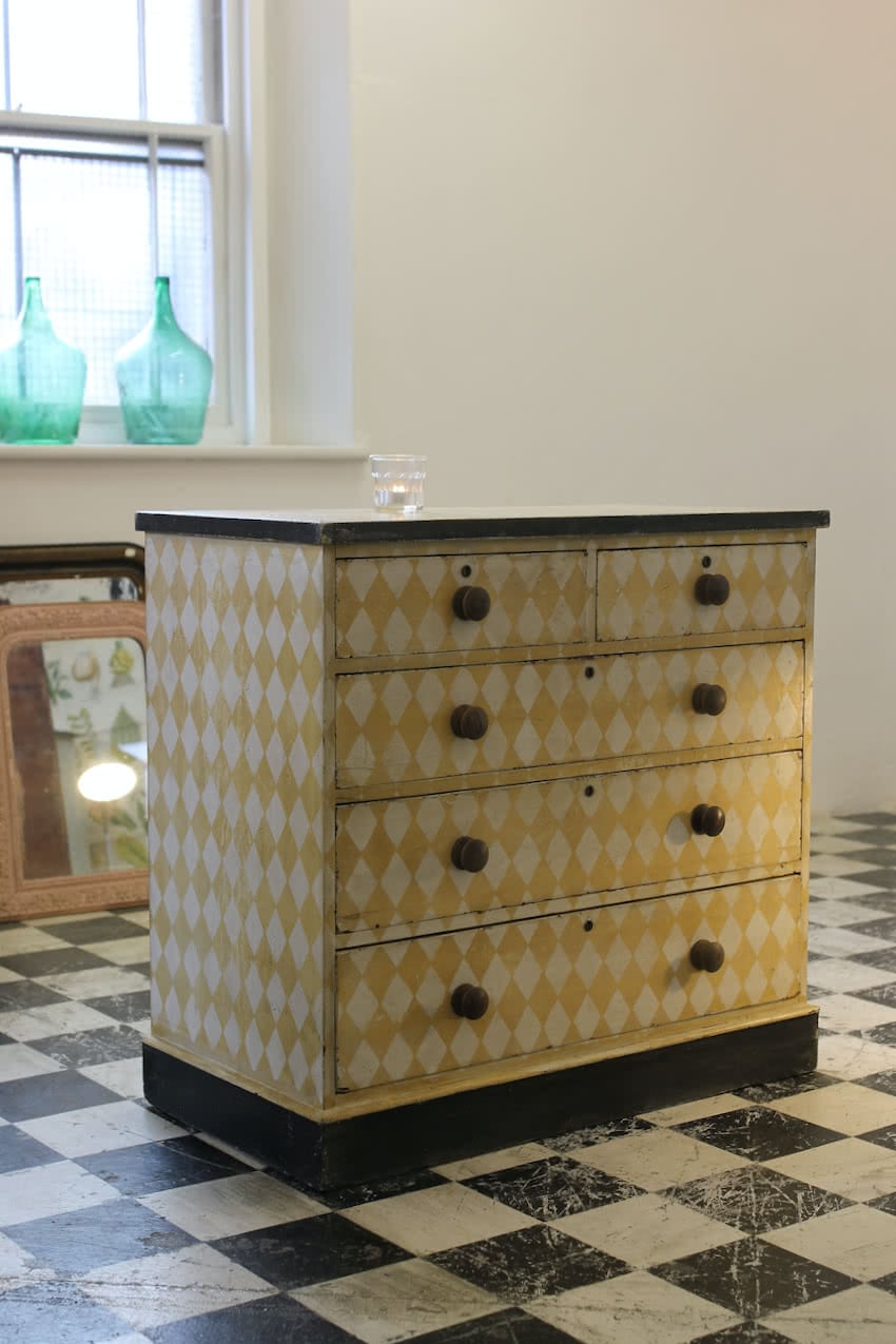 fabulous antique pine chest with lemon & white geometric diamond pattern, contrasting wooden knobs & black plinth.