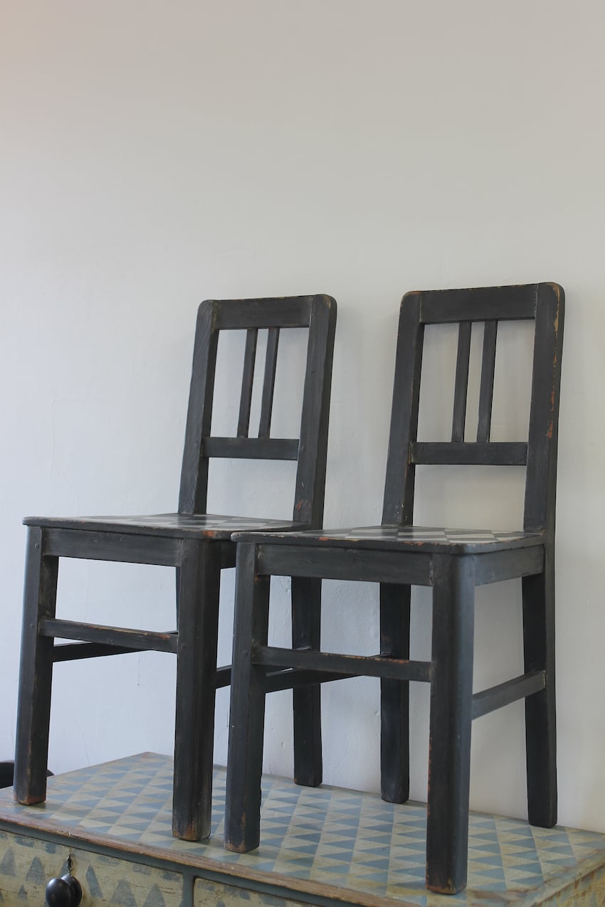 lovely set of four harlequin painted black and white antique pine chairs with hint of orange peaking through.