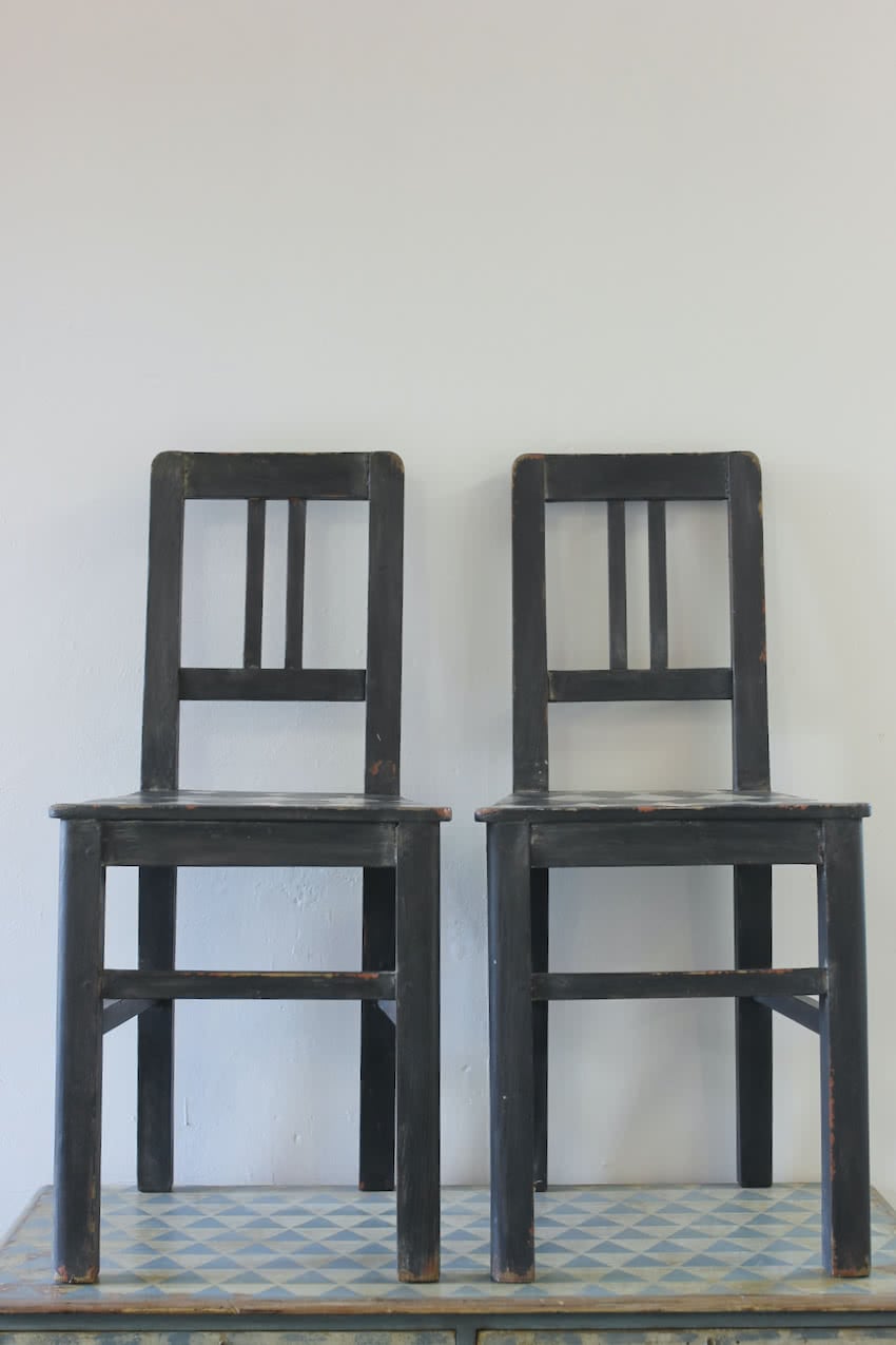 lovely set of four harlequin painted black and white antique pine chairs with hint of orange peaking through.