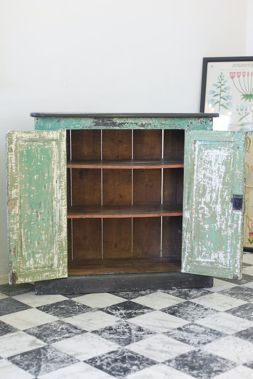 gorgeous pine shelved cupboard hand scraped to reveal the various old colours of paint & mainly green paint with black top and plinth.