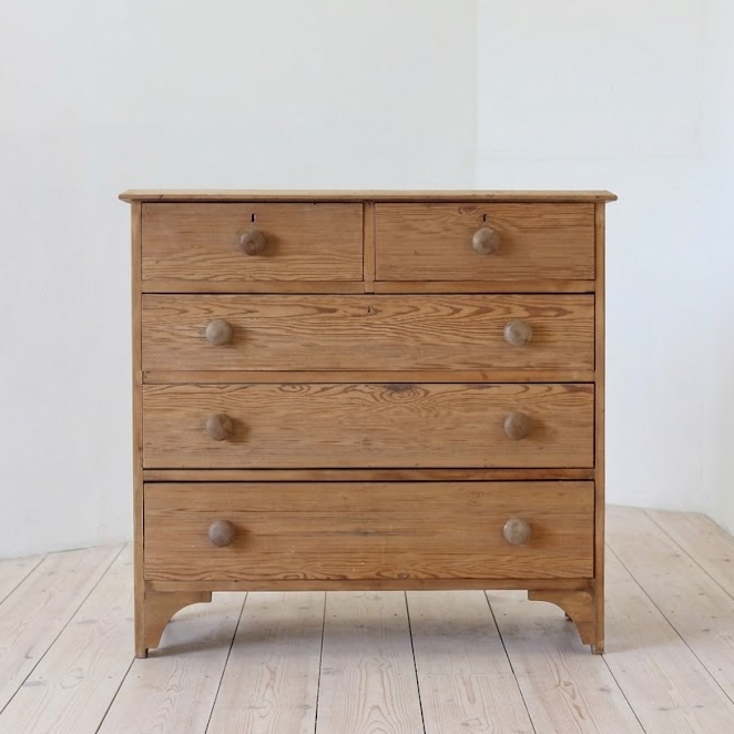 pretty shaped antique pine large chest of drawers with original wooden knobs and arched shaped feet and sides.