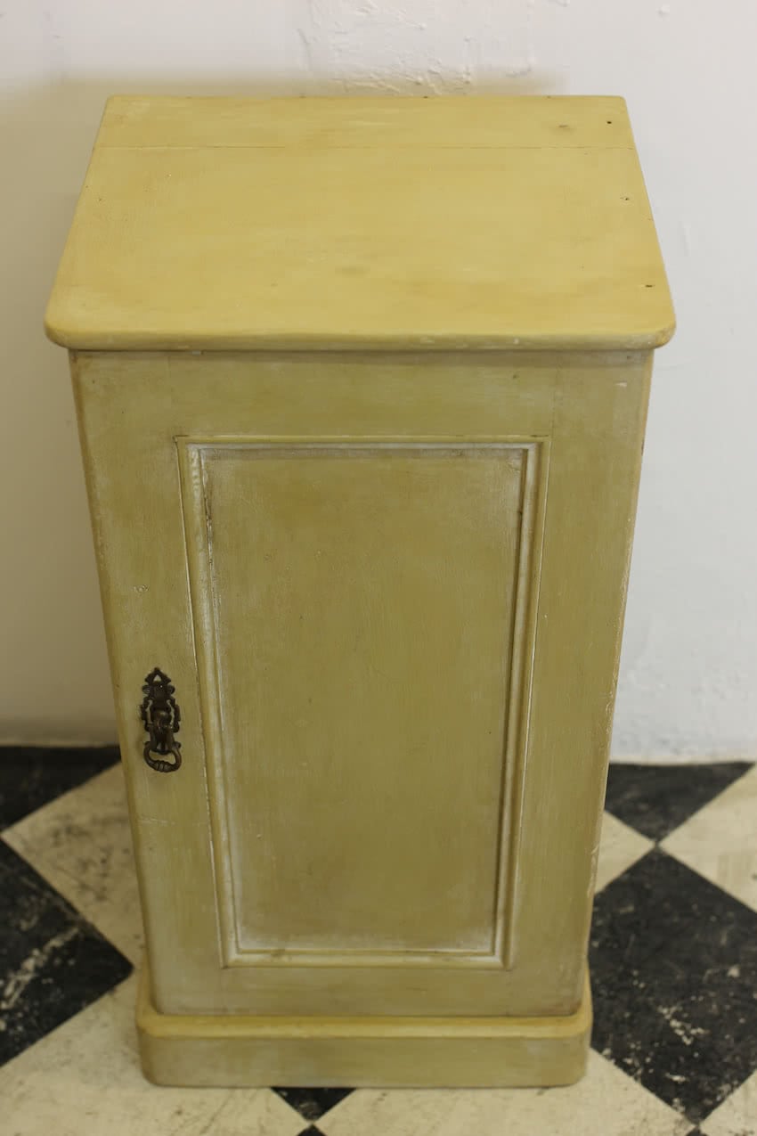 pretty fine pine painted bedside cupboard, there is a small shelf inside and a brass ornate handle & a deep plinth at the base.