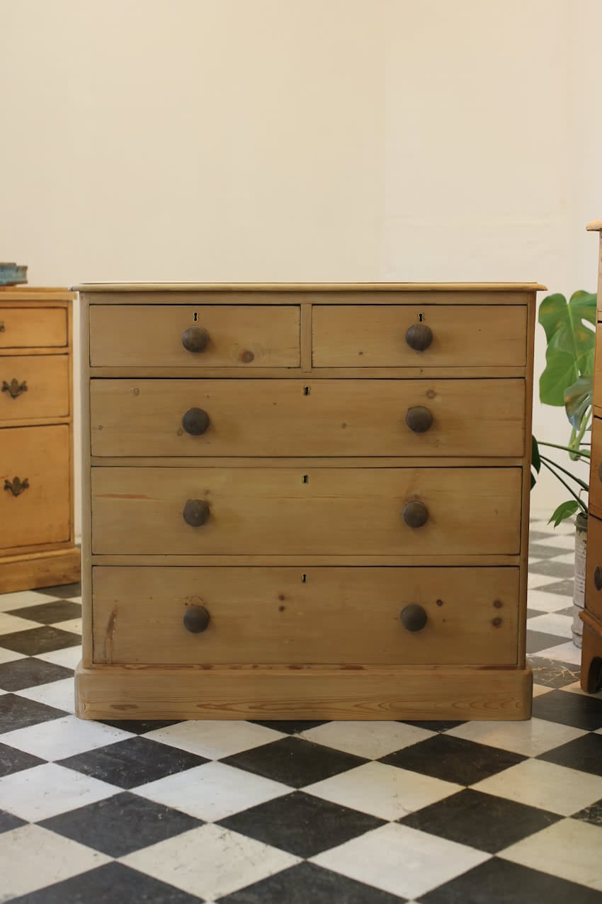large victorian restored pine chest of drawers sitting on plinth with contrasting wooden knobs and a natural, minor repairs shown in photos.
