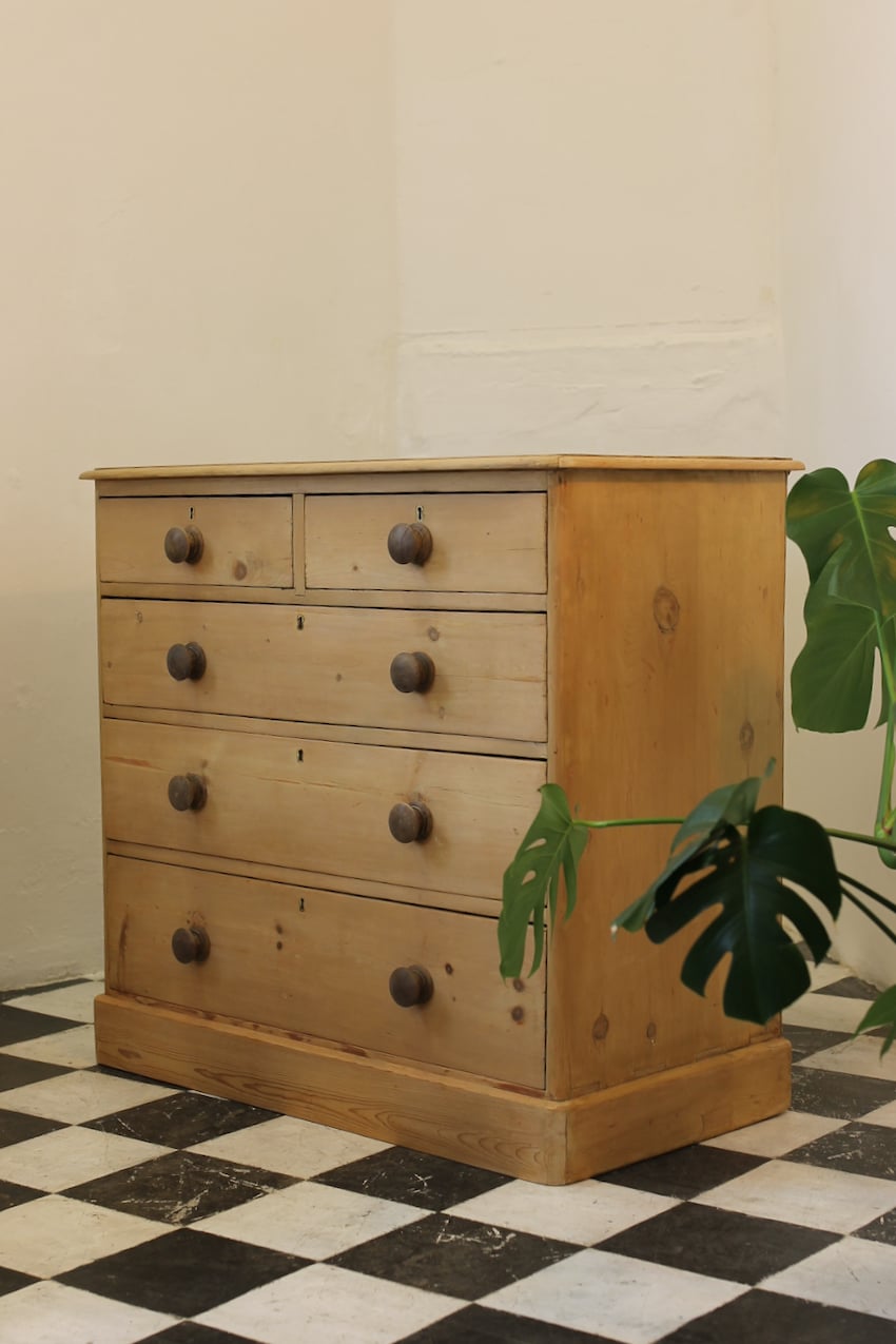 large victorian restored pine chest of drawers sitting on plinth with contrasting wooden knobs and a natural, minor repairs shown in photos.