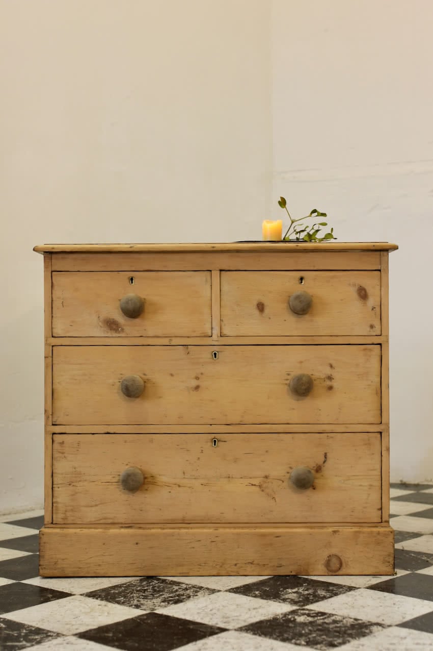 victorian restored rustic looking pine chest with four graduating drawers, wooden knobs and a deep plinth.