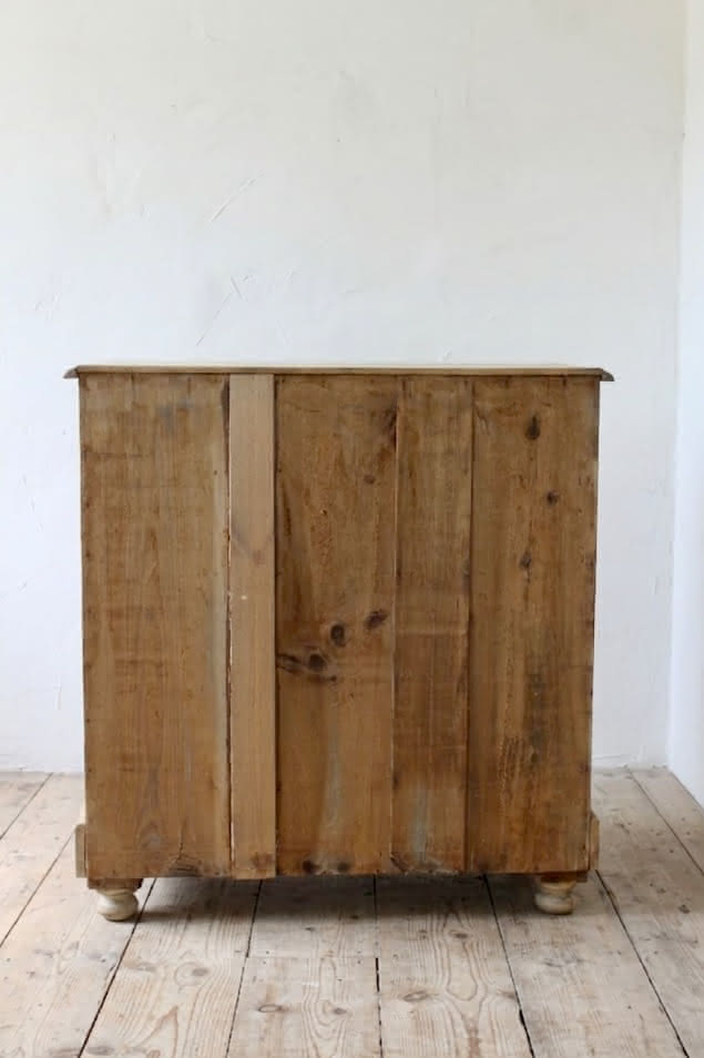lovely looking rustic victorian pine large chest of five graduating deep drawer.s with wooden knobs and original round bun feet.