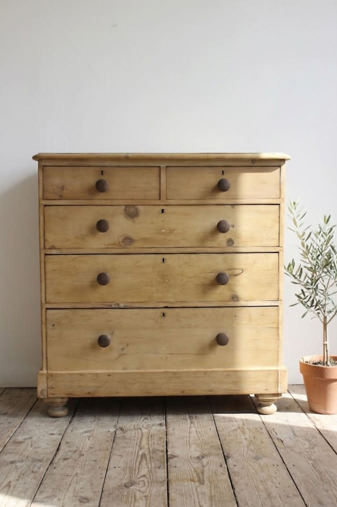 lovely looking rustic victorian pine large chest of five graduating deep drawer.s with wooden knobs and original round bun feet.