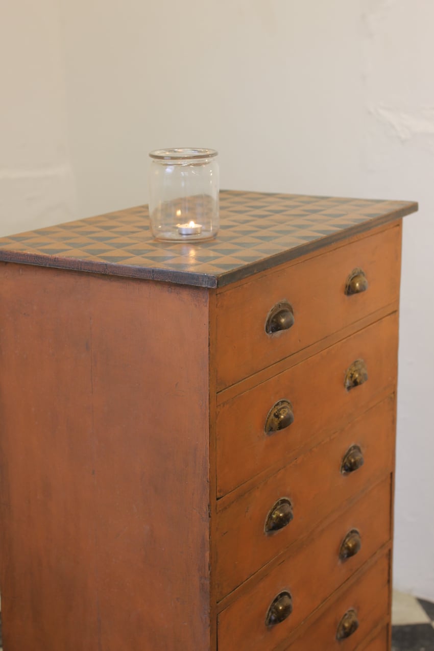 gorgeous restored & painted navy & tangerine pine tall chest of drawers with geometric pattern on the top, the chest has original cup handles and large plinth.