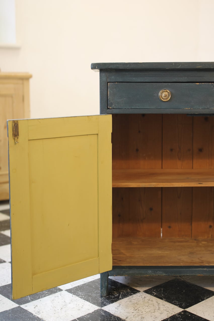 blue painted pine cupboard with two drawers with a shelf, a geometric patterned top & interior doors and drawers painted in Lichen. 