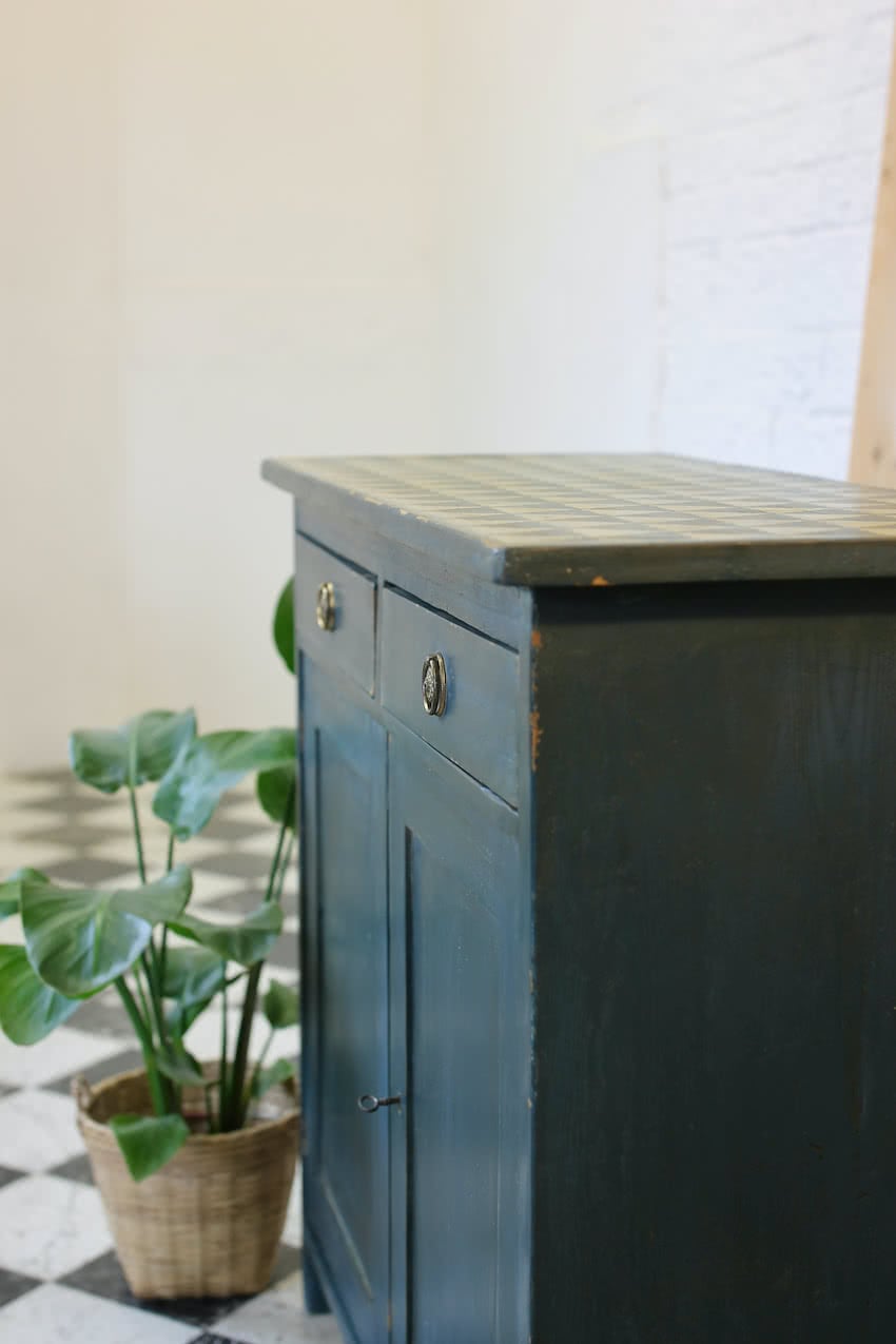 blue painted pine cupboard with two drawers with a shelf, a geometric patterned top & interior doors and drawers painted in Lichen. 