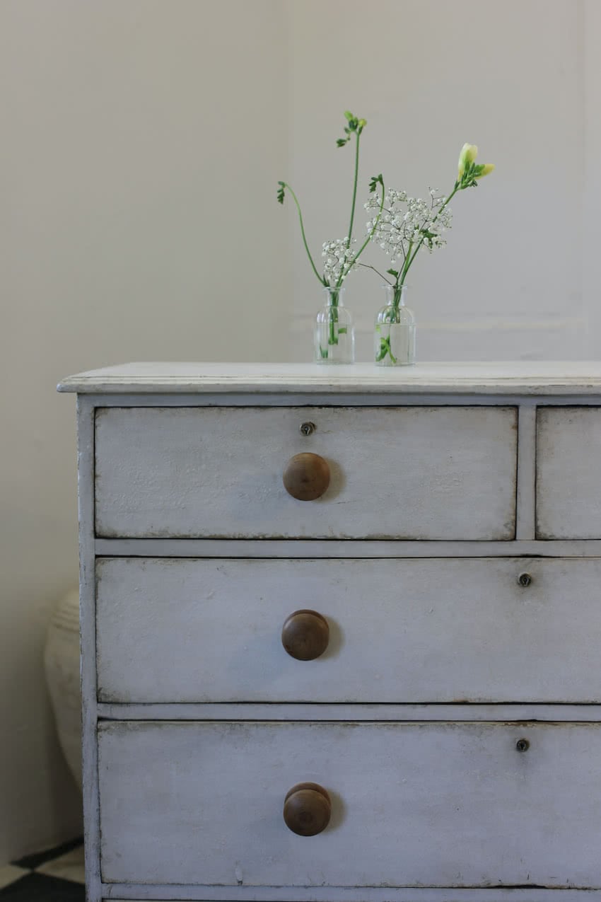 beautiful restored large pine chest refinished in white with contrasting original wooden knobs and lovely turned feet.
